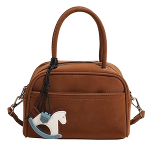 Detailed front view of a matte brown bowling bag featuring a blue horse pendant charm