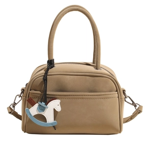 Minimalist matte khaki bowling handbag with curved handles and rocking horse charm decoration