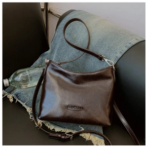 Detail der dunkelbraunen Vintage-Leder-Tote mit verstellbarem Gurt und Silberschnalle