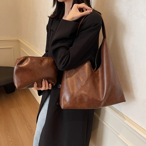 Brown vintage faux leather tote bag set with matching pouch shown on a model