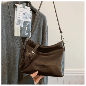 Detail der dunkelbraunen glänzenden Leder-Hobo-Beuteltasche mit silberner Metallschnalle