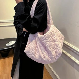 Pink heart quilted large tote bag worn by model with minimalist studio background