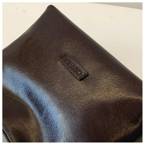 Nahaufnahme der braunen Vintage-Tasche mit dem geprägten C&H EKA Markenlogo auf dem Leder