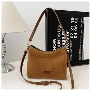 Details der braunen Wildledertasche mit silbernen Beschlägen und Reißverschluss