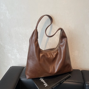 Large vintage brown faux leather tote bag with wide strap and vertical stitching detail