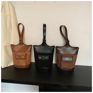 Detailed comparison of three suede bucket bags in caramel, black, and dark brown colors