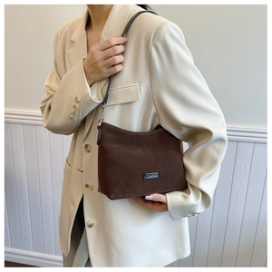 Braune Wildleder-Umhängetasche kombiniert mit beigem Blazer im Retro-Stil