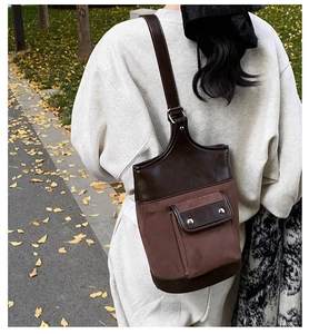 Close-up of vintage suede patchwork shoulder bucket bag with retro metal rivets