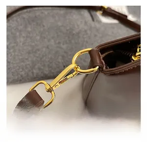Gros plan d'un sac en cuir marron avec des crochets métalliques dorés de haute qualité