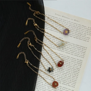 Bracelet en acier inoxydable doré avec pierres naturelles et breloques sur livre rétro