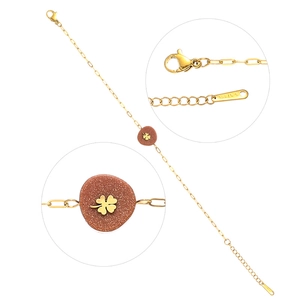 Détail du bracelet en acier doré avec pierre aventurine et breloque trèfle