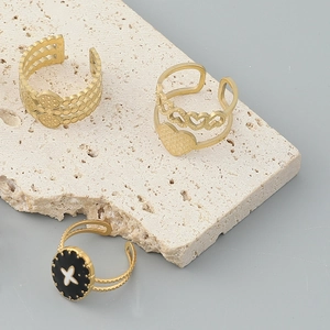 Three-piece gold ring set featuring honeycomb texture, hollow hearts, and black enamel flower