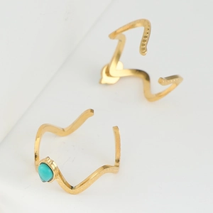 Detail of gold-plated wavy rings set featuring a heart-shaped turquoise stone inlay