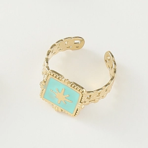 Close-up of golden vintage open ring featuring blue enamel and starburst texture