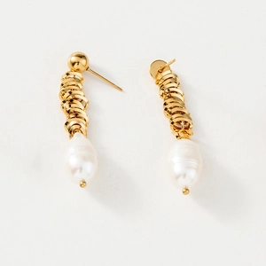 Detailed shot of golden spiral twisted thread earrings with white baroque drop pearls
