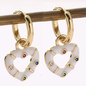 Macro detail of 18K gold heart earrings with white enamel and colorful crystals
