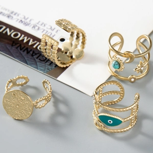 Detail view of a 4-piece set of gold adjustable rings with boho evil eye and star motifs