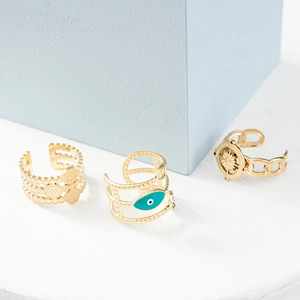 Detailed view of evil eye and compass star engraved gold adjustable steel rings