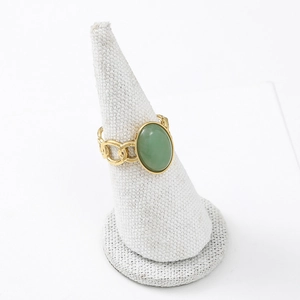 Close-up of gold chain-style ring featuring an oval green natural stone on a display