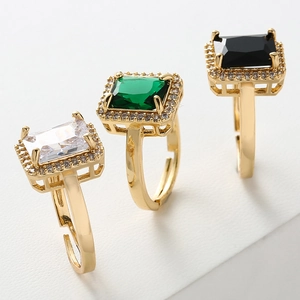 Detailed view of adjustable gold rings with emerald-cut zirconia in green and black