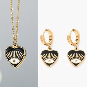 Détail du pendentif cœur doré avec émail œil porte-bonheur sur collier en acier