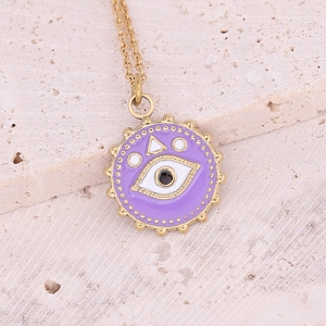Macro shot of gold Evil Eye necklace with purple enamel pendant on stone background