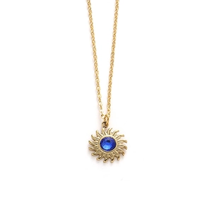 Golden sun pendant necklace with a blue gemstone center on a delicate link chain