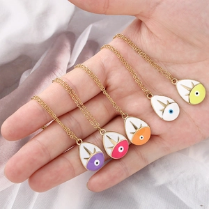 Macro shot of colorful evil eye teardrop pendants on fine gold chains for women