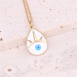 Detailed close-up of a gold water-drop pendant with white enamel and evil eye motif