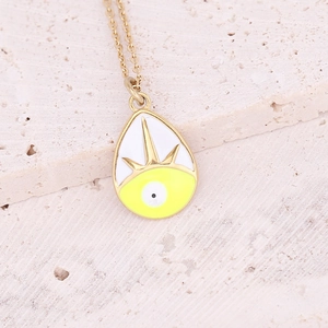 Detailed close-up of a golden teardrop pendant with yellow and white enamel evil eye design