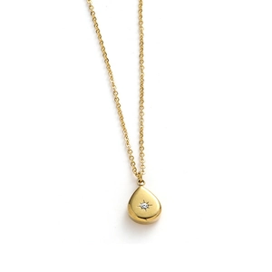 Detailed view of water-drop pendant in gold finish with starburst engraving and gemstone