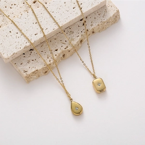 Detailed close-up of gold water drop and rectangle pendants with star-set cubic zirconia