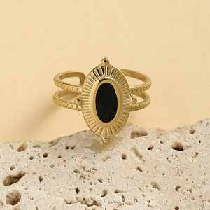 Bague vintage en acier inoxydable doré avec émail noir ovale sur un socle en pierre naturelle