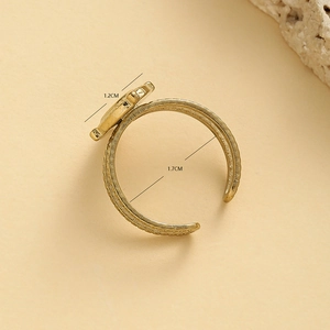 Bague ouverte vintage en acier doré avec goutte d'huile noire et texture ondulée