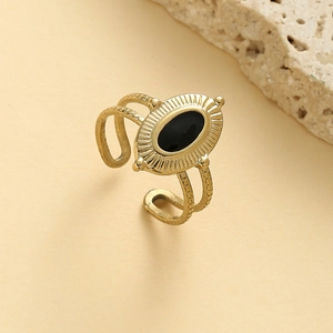 Détail d'une bague ovale en acier doré à l'huile noire avec texture rayon de soleil
