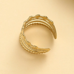 Macro detail of gold adjustable multi-layer ring featuring a wave textured finish