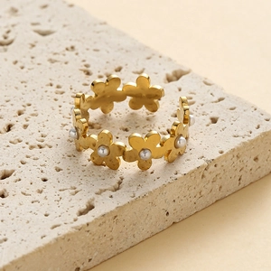 Elegant gold-plated stainless steel daisy ring with pearls on a natural stone surface