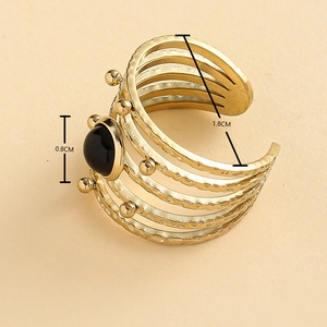 Golden multilayer hollow ring with oval black stone and hammered metal texture finish
