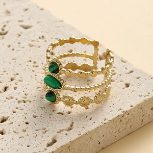 Detail of bohemian gold hollow layered ring set with three green oval malachite stones