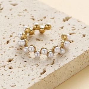 Bague en acier inoxydable doré à ondes avec perles blanches sur socle en pierre