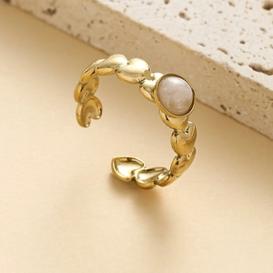 Detail of gold heart-shaped adjustable ring with inlaid round zircon on stone base