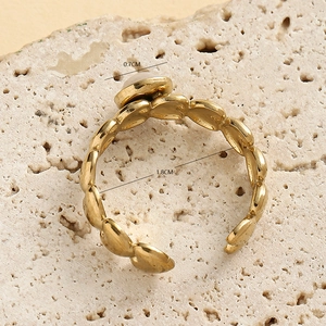 Gold stainless steel heart ring with 0.7cm round inlay on a stone background