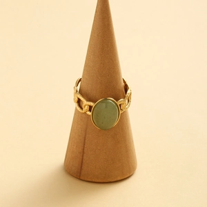 Vintage gold-plated chain ring with an oval green stone on a wooden display stand