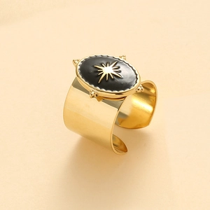 Detail of wide gold adjustable ring with black enamel starburst pattern in vintage style
