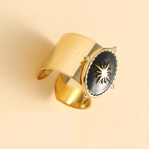Detail of wide gold adjustable ring with black enamel inlay and starburst motif