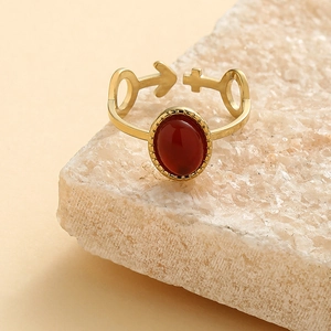 Detail of gold adjustable ring with oval red stone and Mars Venus gender symbols