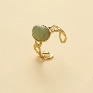 Macro view of oval green gemstone ring with gold-toned hammered chain texture band
