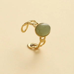 Detail view of oval green gemstone set in gold vintage style adjustable hollow ring band