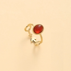 Detail of gold ring featuring red oval stone and male-female gender symbol design