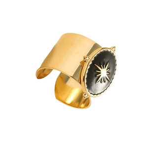Wide gold adjustable ring featuring a black enamel circle and celestial starburst design